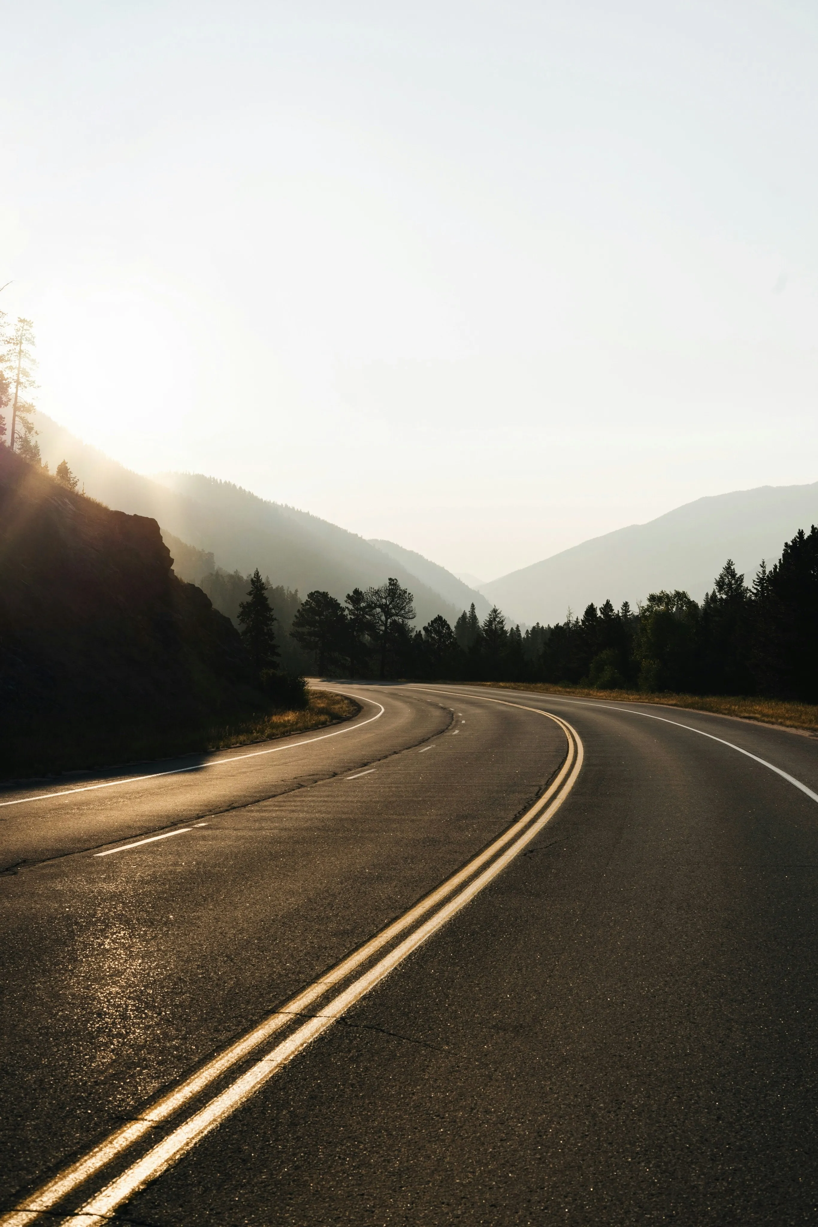 Sonnenbeschienene Bergstraße in der Morgendämmerung
